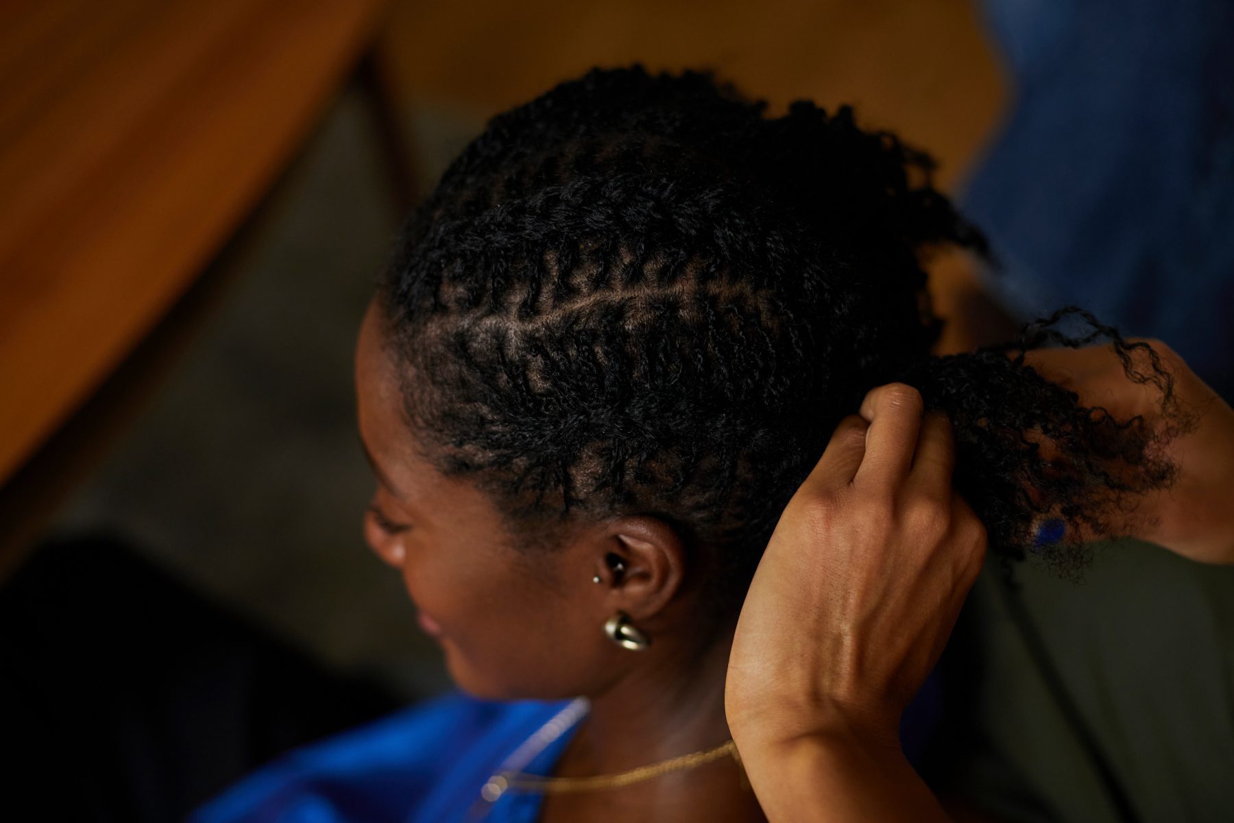 Woman with braided hair styling or adjusting her updo hairstyle